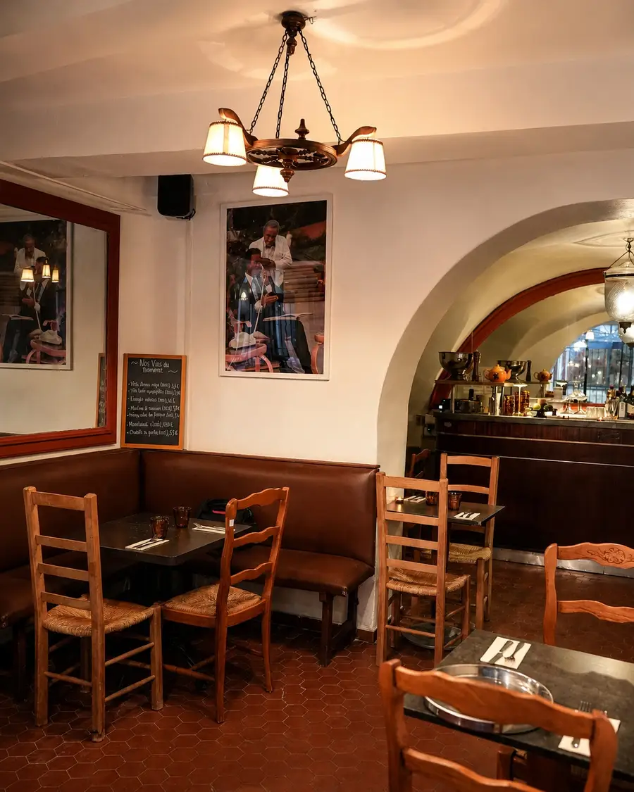 Banquette en cuir, chaises paillées et lustre au-dessus des tables